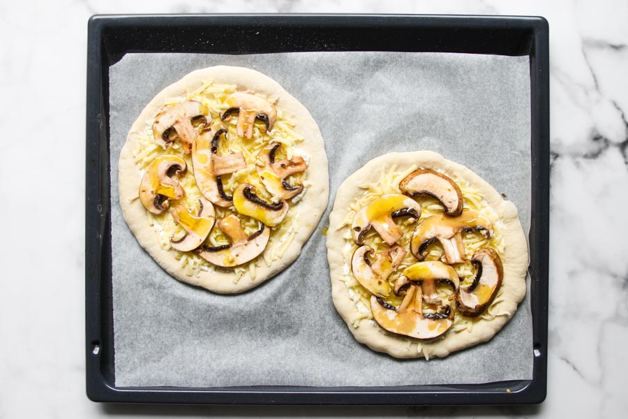 Mushroom pizza on baking sheet
